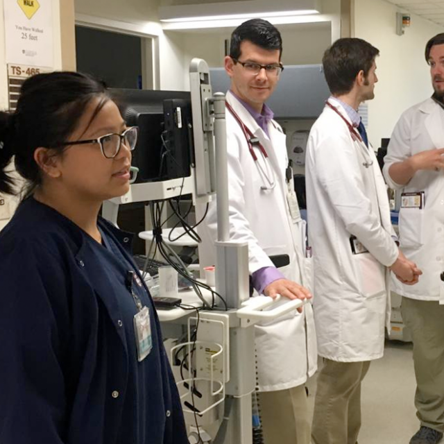 Female clinician standing next to medical equipment